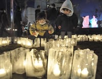 氷の燭台の明かりに見とれる子どもたち＝諏訪市の柳並公園