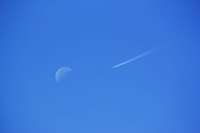 昼間の月とジェット旅客機